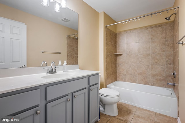 full bathroom with tiled shower / bath, vanity, tile patterned floors, and toilet