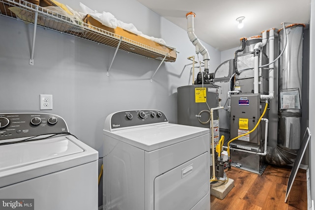 clothes washing area featuring dark wood-type flooring, independent washer and dryer, and gas water heater