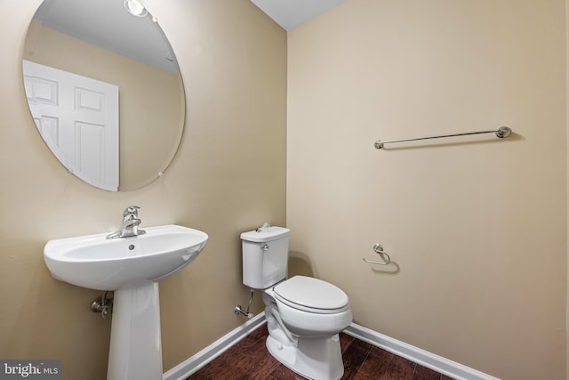 bathroom featuring sink, hardwood / wood-style floors, and toilet