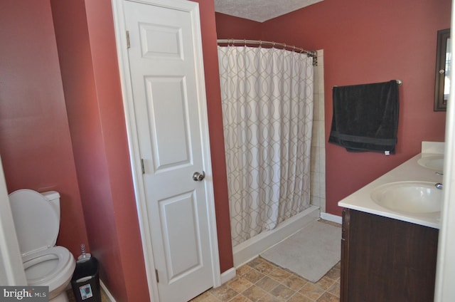 bathroom with a shower with curtain, vanity, toilet, and a textured ceiling