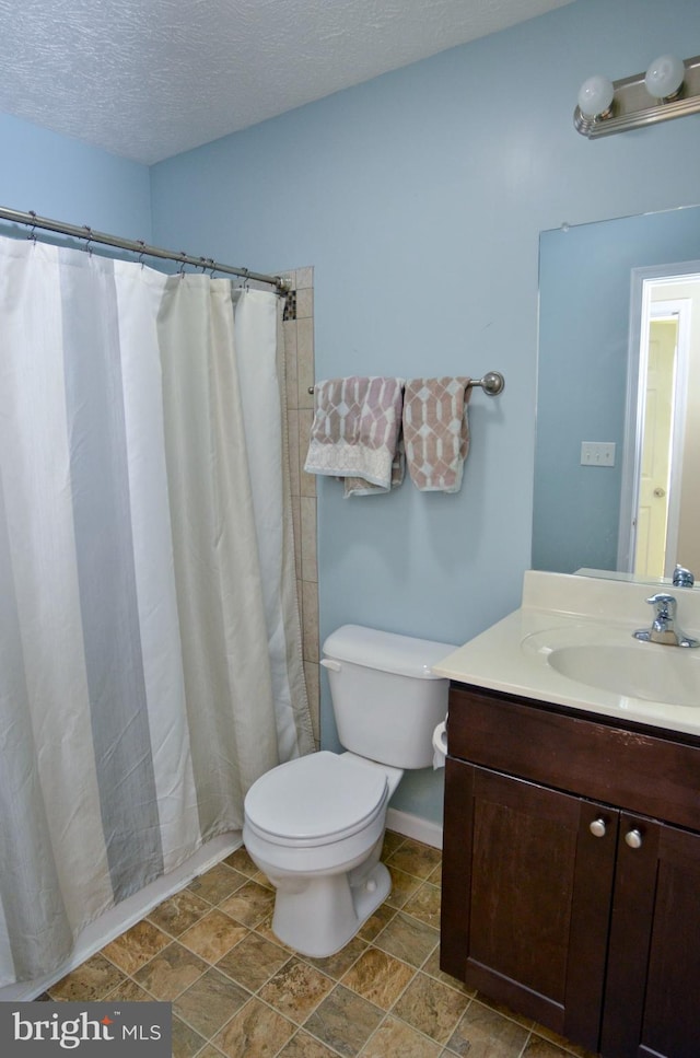 bathroom with a shower with curtain, vanity, toilet, and a textured ceiling