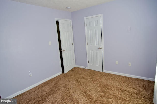 unfurnished bedroom featuring carpet floors and a textured ceiling