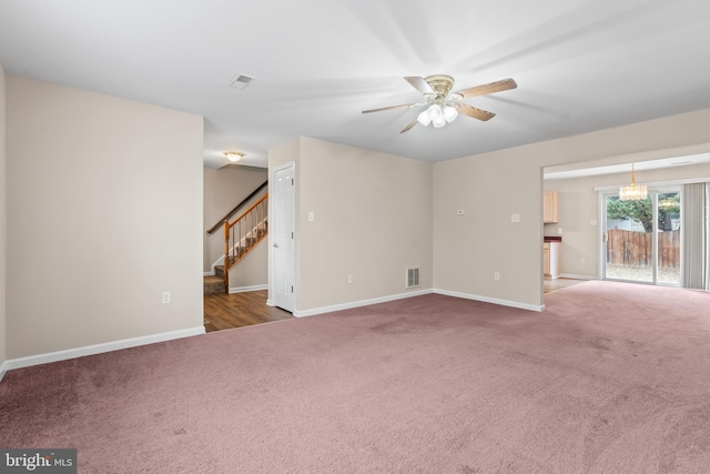 carpeted spare room with ceiling fan with notable chandelier