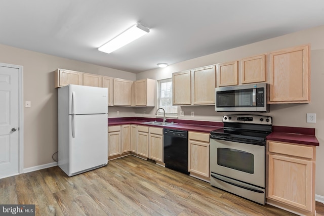 kitchen featuring light brown cabinetry, sink, light wood-type flooring, and appliances with stainless steel finishes