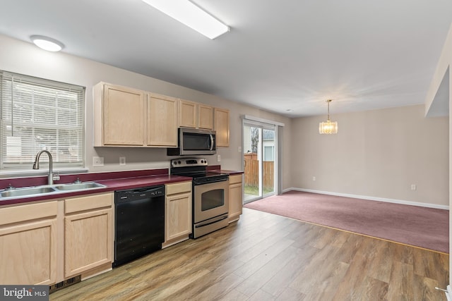 kitchen with pendant lighting, sink, stainless steel appliances, light brown cabinets, and light hardwood / wood-style flooring