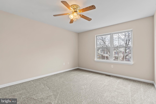 carpeted spare room featuring ceiling fan