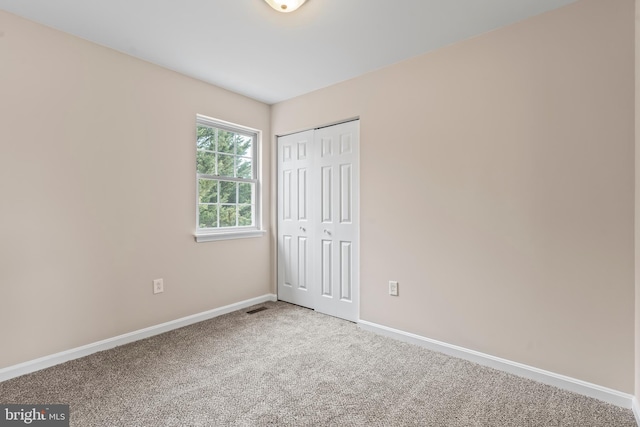 unfurnished bedroom with a closet and carpet