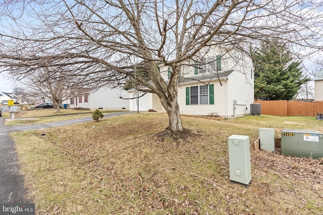 view of front of home with cooling unit and a front yard