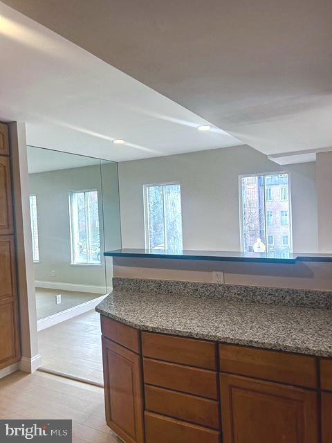 interior space with light wood-style flooring, baseboards, and open floor plan