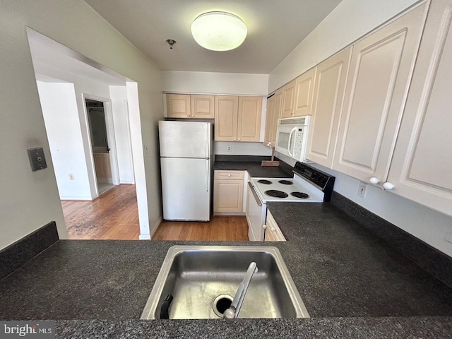 kitchen featuring white appliances, sink, and light hardwood / wood-style flooring