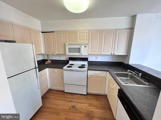 kitchen featuring sink, white appliances, and light wood-type flooring