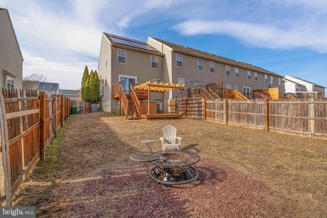 back of property featuring a wooden deck and an outdoor fire pit