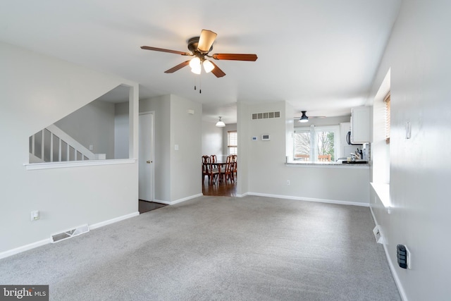 unfurnished living room featuring ceiling fan and carpet