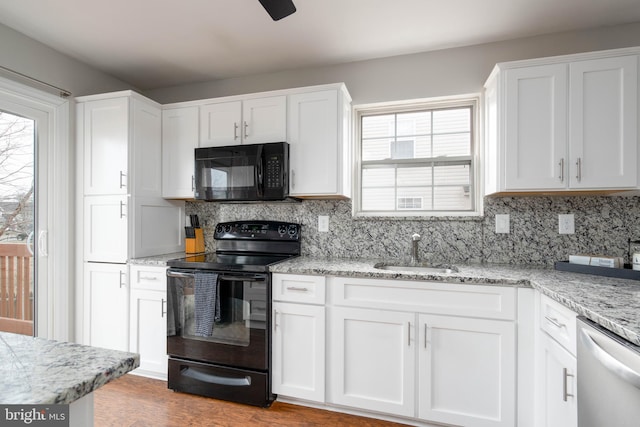 kitchen with white cabinetry, sink, decorative backsplash, and black appliances