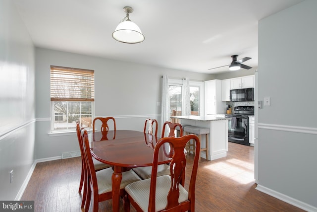 dining space with wood-type flooring and ceiling fan