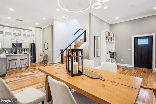 dining room with ornamental molding and light hardwood / wood-style floors