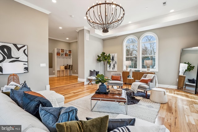 living room featuring ornamental molding, a chandelier, and light wood-type flooring