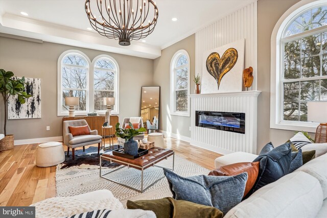 living area featuring hardwood / wood-style floors, a notable chandelier, and ornamental molding