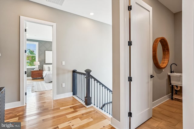 corridor featuring sink and light hardwood / wood-style floors