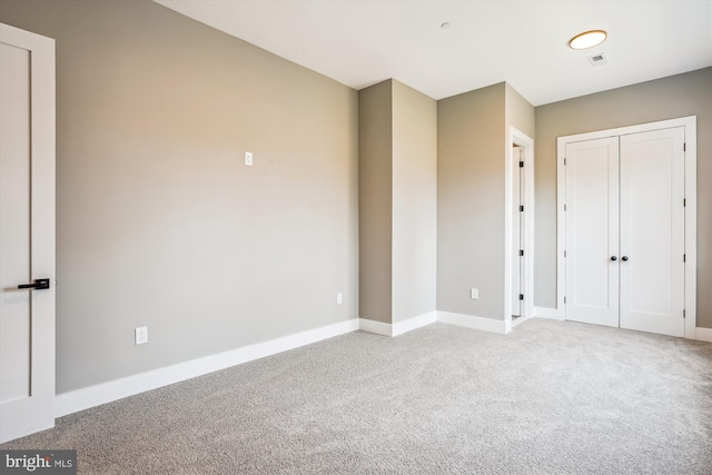 unfurnished bedroom featuring carpet flooring and a closet