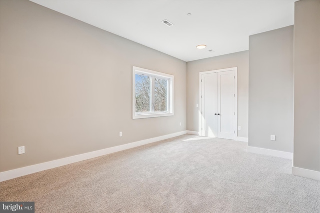 spare room featuring light colored carpet