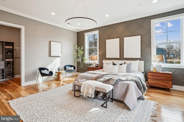 bedroom featuring crown molding and light hardwood / wood-style flooring