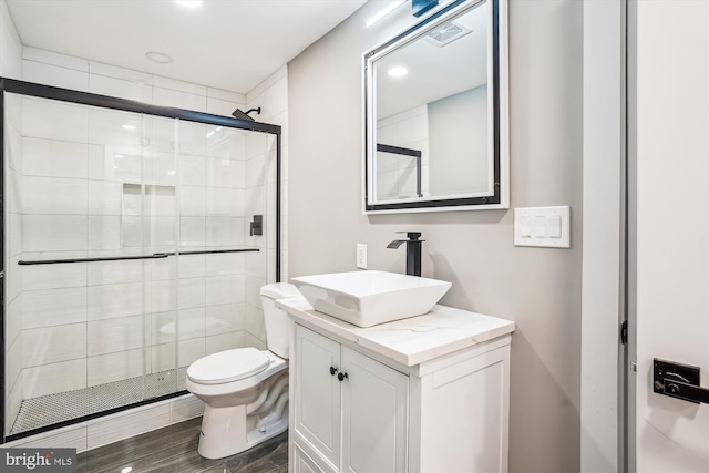 bathroom featuring walk in shower, vanity, and toilet