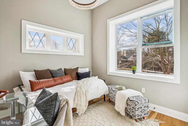 bedroom with multiple windows and hardwood / wood-style flooring