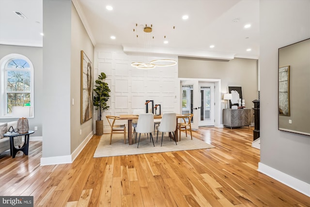 dining area featuring crown molding, light hardwood / wood-style floors, and french doors