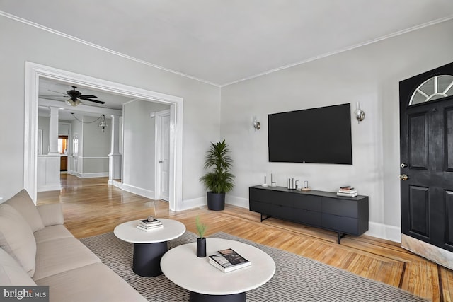 living room featuring wood-type flooring, ornamental molding, and ceiling fan