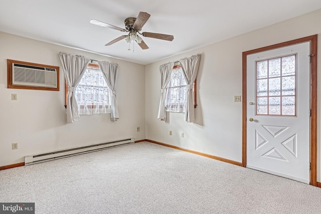 spare room with a baseboard heating unit, a wealth of natural light, ceiling fan, and carpet flooring