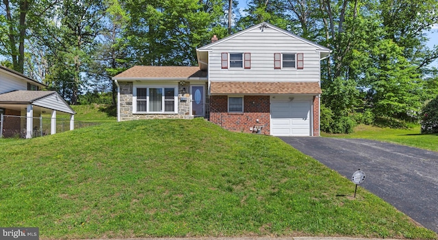 tri-level home featuring a garage, asphalt driveway, brick siding, and a front yard