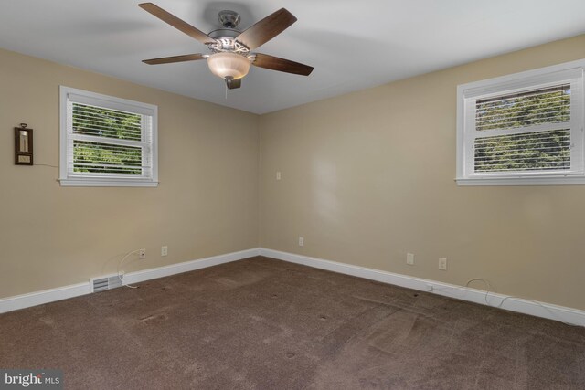 carpeted empty room featuring baseboards and a ceiling fan