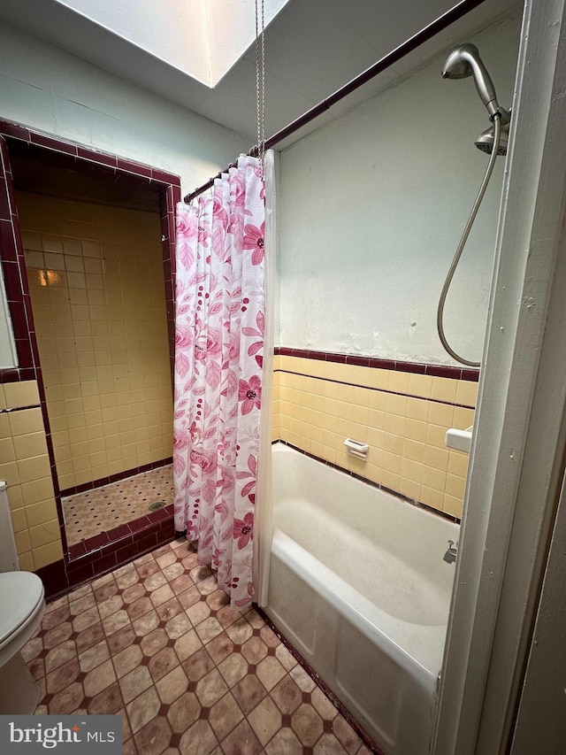 bathroom featuring shower / bathtub combination with curtain and toilet