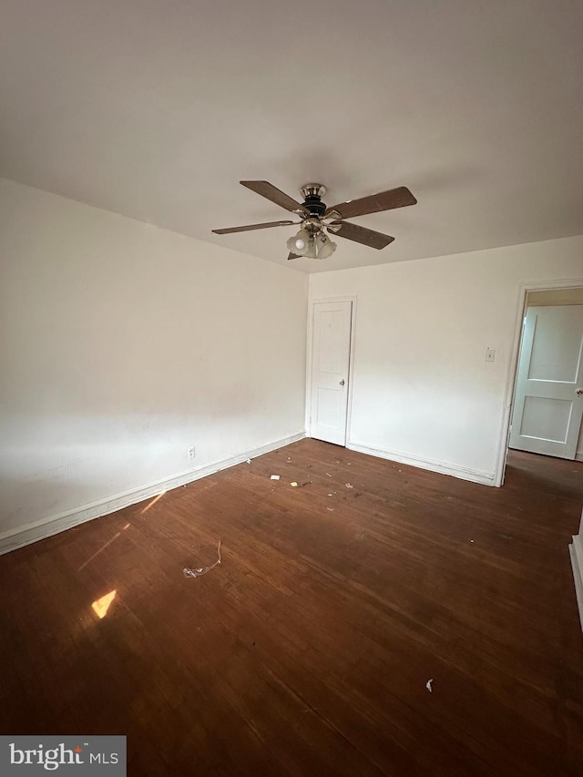 empty room with dark hardwood / wood-style floors and ceiling fan