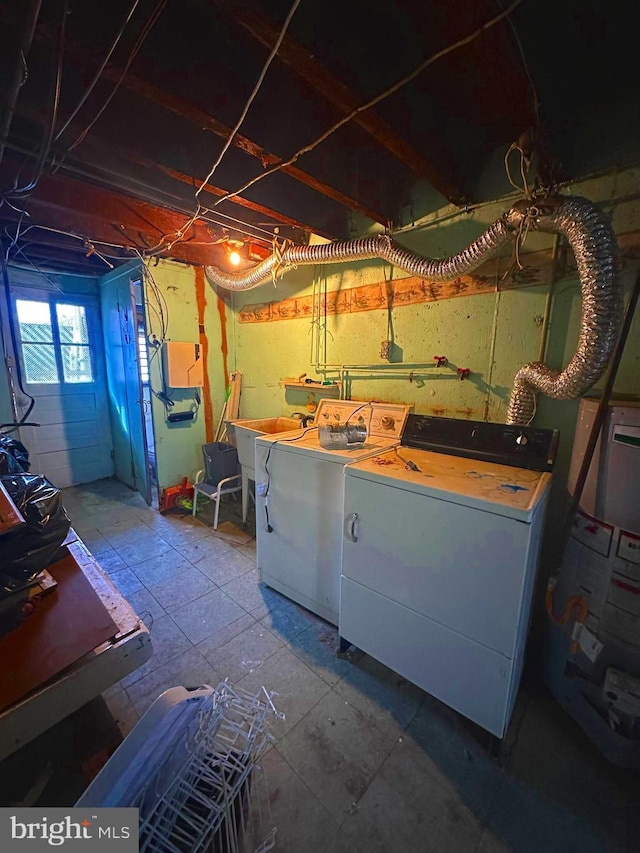 clothes washing area with washer and clothes dryer, sink, and water heater