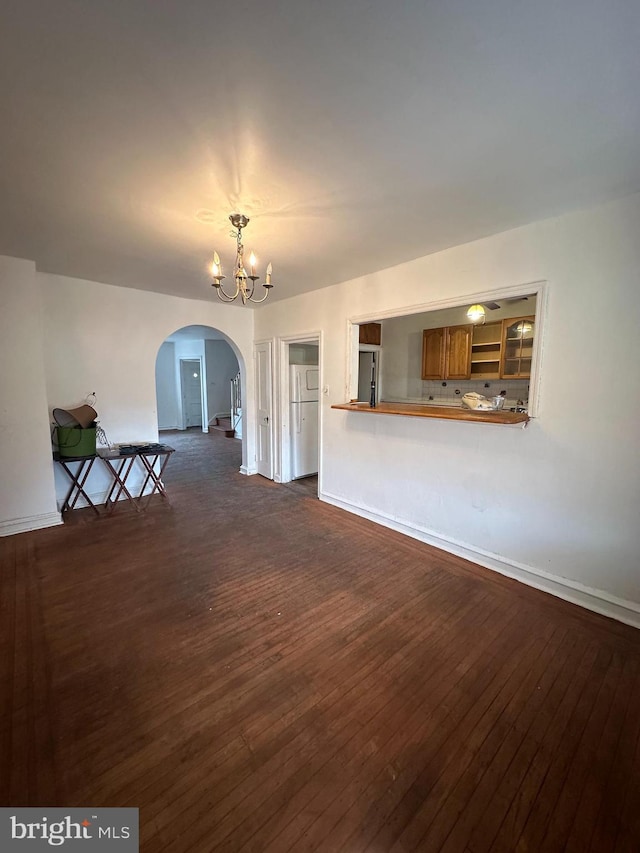 unfurnished living room with dark hardwood / wood-style floors and a notable chandelier