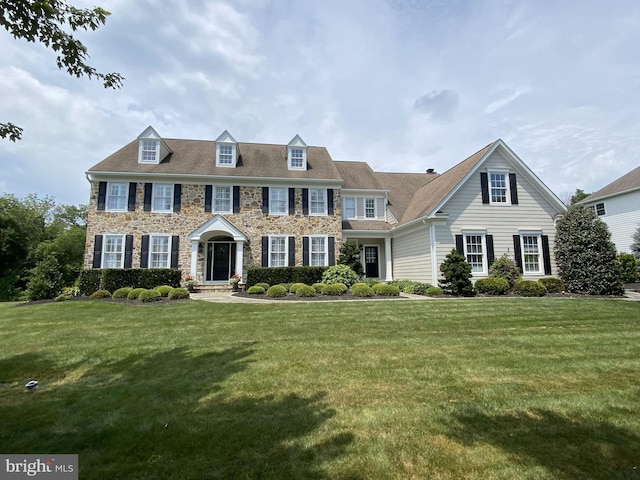 colonial-style house featuring a front yard