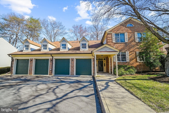 view of front of house featuring brick siding, an attached garage, and driveway