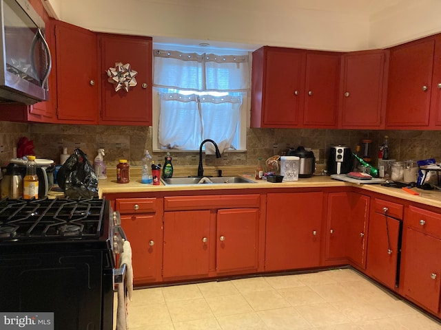 kitchen with appliances with stainless steel finishes, sink, and decorative backsplash