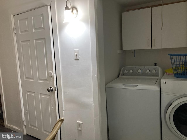 washroom with cabinets and washer and dryer