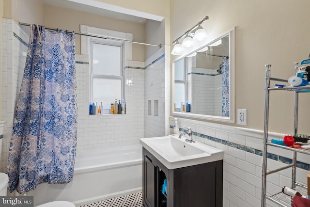 full bathroom with vanity, toilet, shower / tub combo, and tile walls