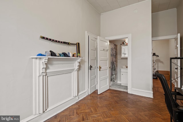 interior space with dark parquet flooring and crown molding