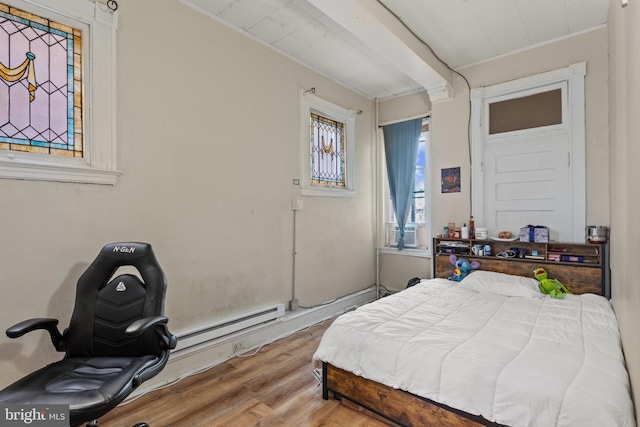 bedroom featuring hardwood / wood-style floors and baseboard heating