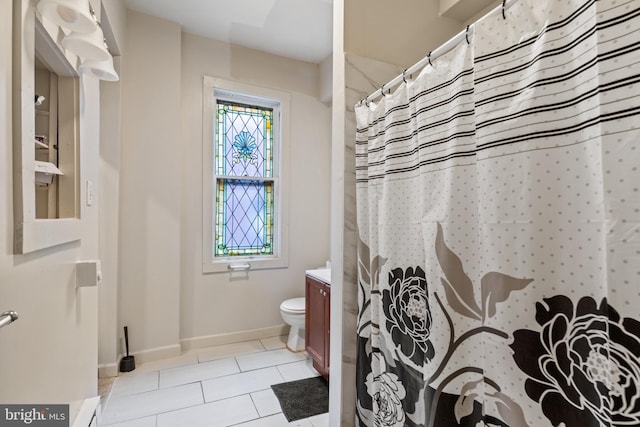 bathroom with vanity, tile patterned flooring, toilet, and walk in shower