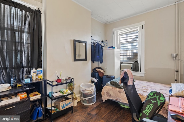 bedroom with ornamental molding and dark wood-type flooring