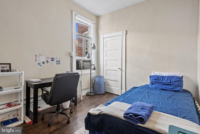 bedroom with a baseboard heating unit, dark wood-type flooring, and cooling unit