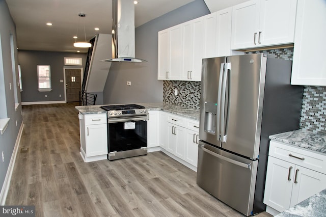 kitchen featuring stainless steel appliances, island exhaust hood, light stone countertops, and white cabinets