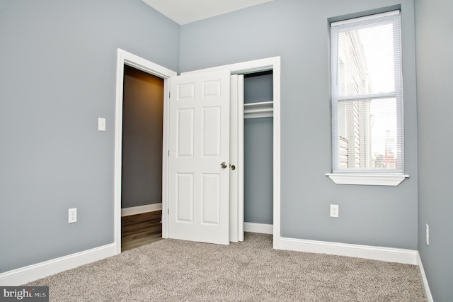 unfurnished bedroom with a closet and light carpet