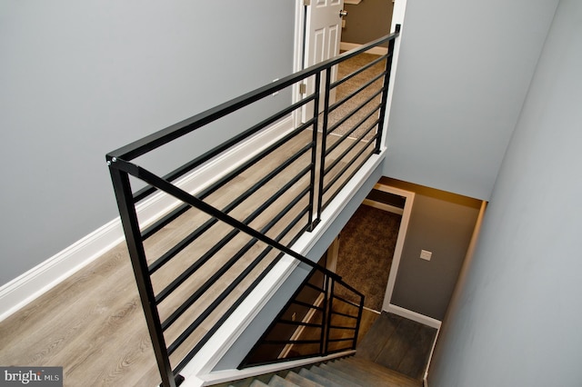 staircase with hardwood / wood-style floors